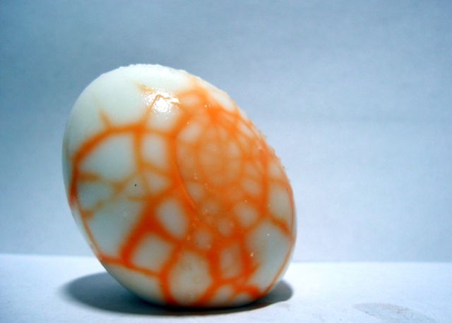 A hard-boiled egg with egg dye all over it.