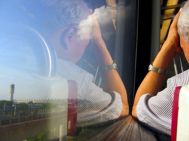 A metro rider holds head in hand as the conductor announces all trains are stopped on the yellow line for some unexplicable reason.