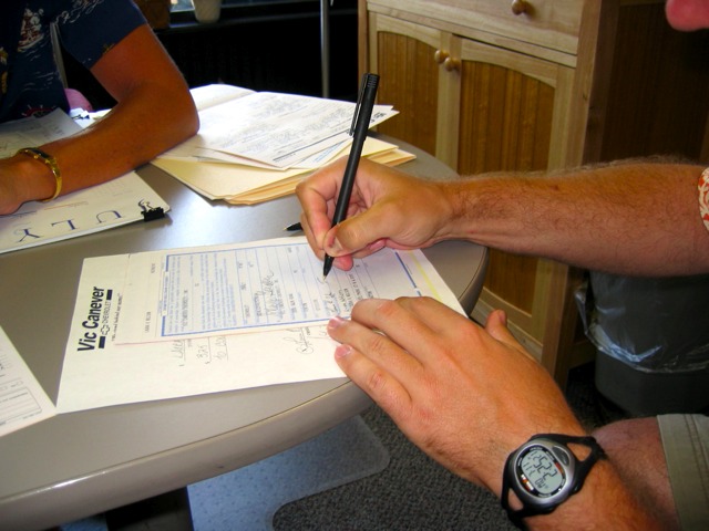 Signing the paperwork to buy a new car.