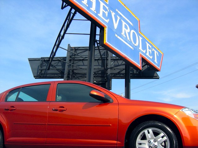 Our new car in the shadow of the giant Chevrolet bowtie.