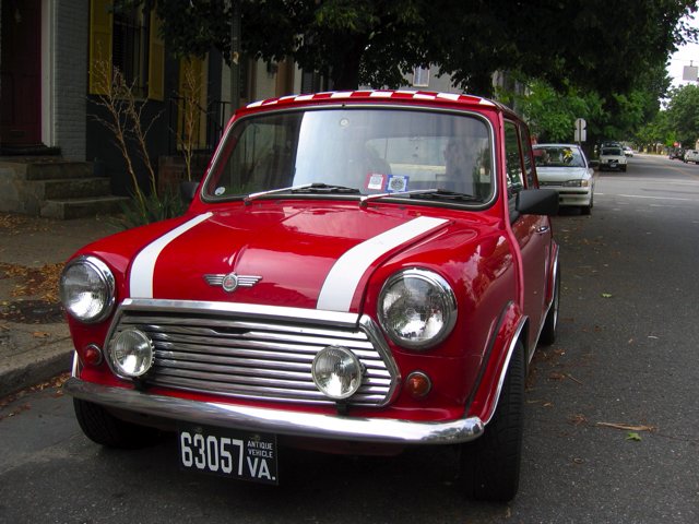 An original Mini Cooper sits on the street.