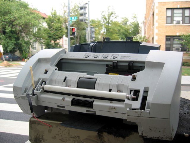 A discarded inkjet printer atop a utility box at the corner of R and 19th.