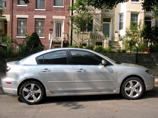 A new Mazda 3 parked in the neighborhood.