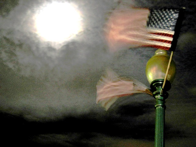 The nearly full moon illuminates the flags flapping in the breeze along the Potomac in Georgetown.