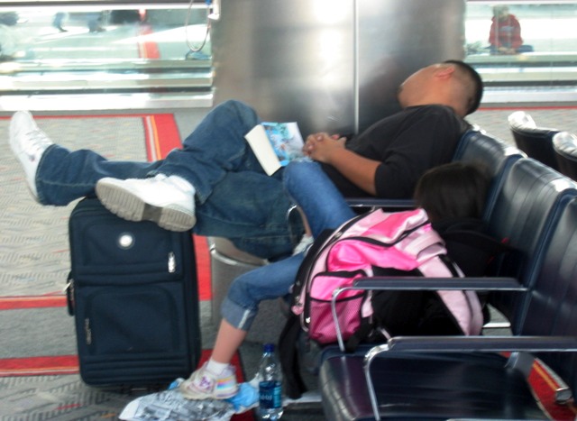 A father and daughter catch some sleep at Denver International Airport on New Year's Eve day.