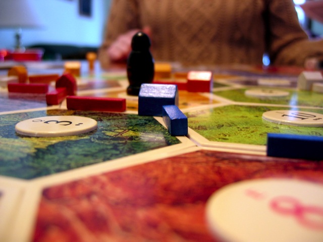 A macro shot of the Settlers of Catan game board  in the middle of a game.