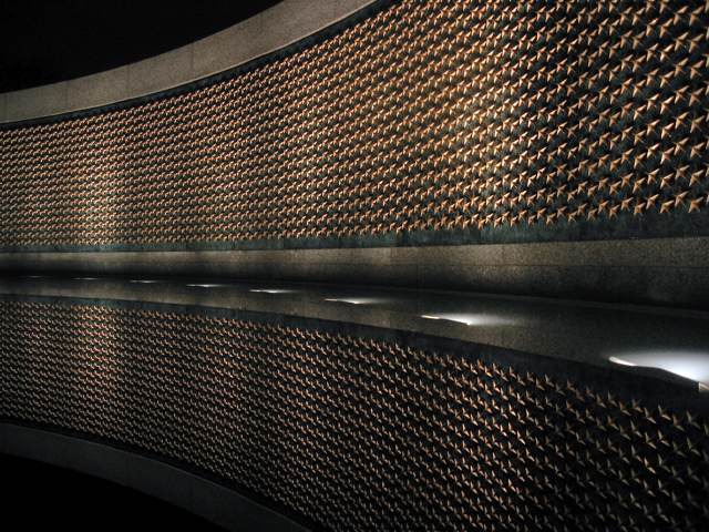 The wall of shiny stars at the World War II Memorial looks down at its reflection.