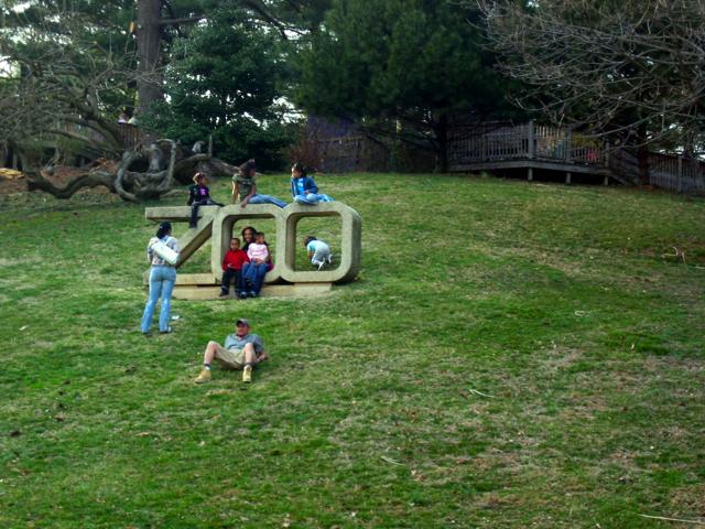 Kids play and pose on the big concrete zoo letters.